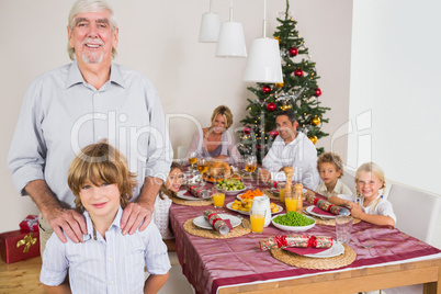 Grandfather and grandson standing beside the dinner table