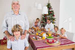 Grandfather and grandson standing beside the dinner table