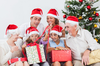 Family watching little girl opening christmas present
