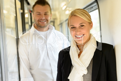 Woman and man smiling standing in train