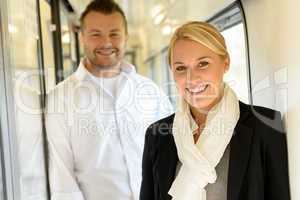 Woman and man smiling standing in train