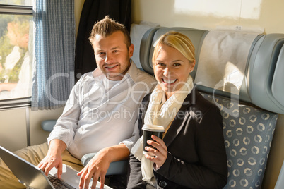 Woman and man sitting in train smiling