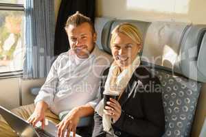 Woman and man sitting in train smiling