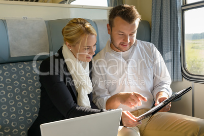 Woman and man in train laptop clipboard