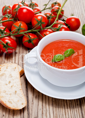 Frische tomatensuppe in einer weißen suppentasse mit basilikum