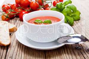 Frische tomatensuppe in einer weißen suppentasse mit basilikum