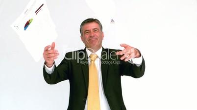 Smiling businessman throwing papers