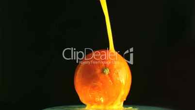 Orange juice pouring over an orange
