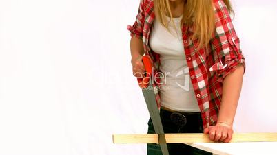 Blonde woman sawing a wood plank