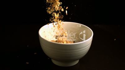 Muesli pouring into a white bowl