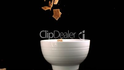 Square cereal falling in a bowl