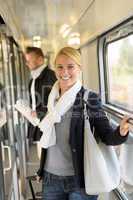 Woman smiling in train hall with luggage