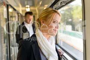 Woman in train looking pensive on window