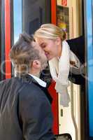 Man kissing woman goodbye train leaving romance