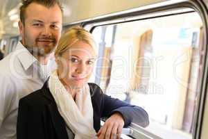 Woman and man standing by train window