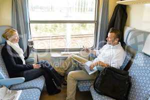 Man and woman sitting in train talking