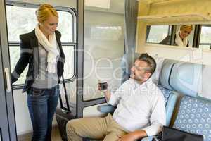 Woman getting in train compartment with man