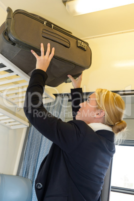 Woman putting her luggage on train grid