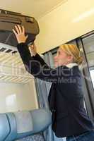 Woman putting her baggage on train grid