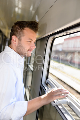 Man looking out the train window smiling