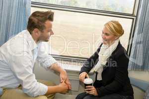 Woman and man traveling with train talking