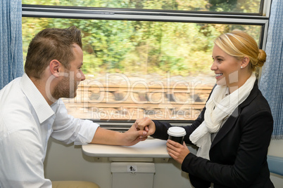 Woman and man on train holding hands