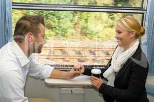 Woman and man on train holding hands