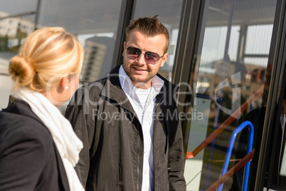 Man and woman talking waiting for bus