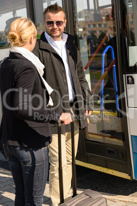 Woman and man talking in bus station