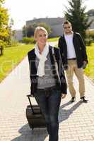 Woman leaving with baggage man walk behind