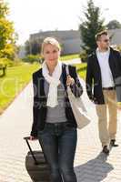 Woman arriving in park with baggage man
