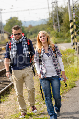 Couple walking with backpack in train station