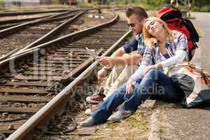 Couple resting looking at map railroad backpack