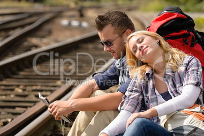 Couple backpack traveling resting on railroad map