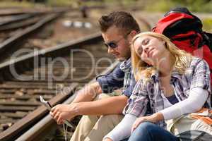 Couple backpack traveling resting on railroad map