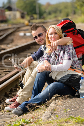 Man pointing direction to woman with map