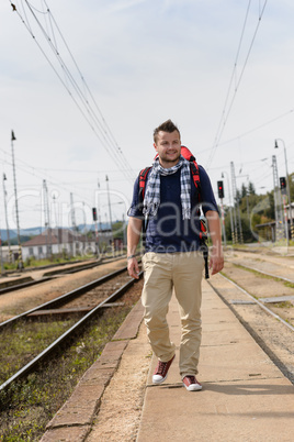 Man walking towards train station backpack travel
