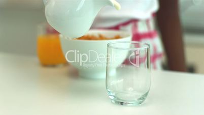 Milk being poured into a glass at breakfast