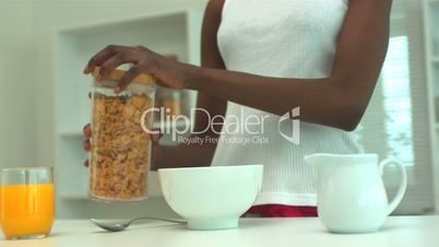 Woman pouring out cereal for breakfast