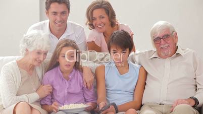 Multi-generation family on couch watching tv