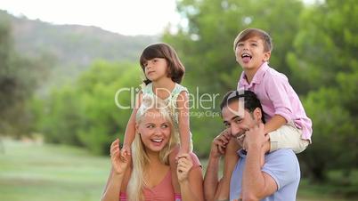 Parents carrying their children on their shoulders