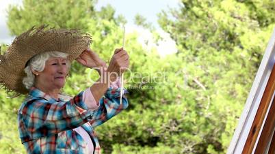 Old woman painting in the park