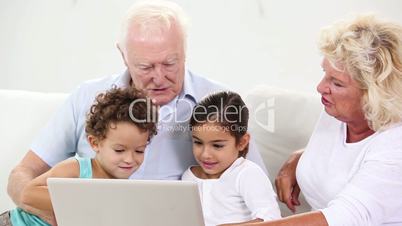 Children and grandparents using a laptop