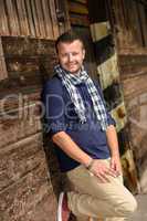 Man posing leaning against wooden wall fashion