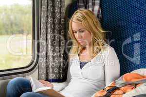 Woman reading while traveling with the train