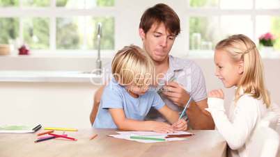 Siblings drawing with their father