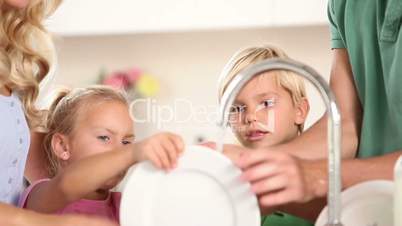 Parents washing dishes with their children
