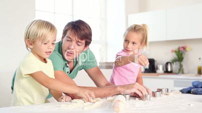 Father and his children kneading a dough