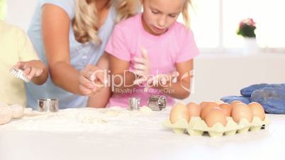 Mother and father kneading a dough with their children