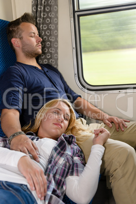 Couple resting with eyes closed in train